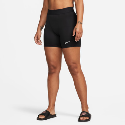 Ein Model in schwarzen Nike-Shorts mit Logo und schwarzen Slides an den Füßen. Ein Model in schwarzen Nike-Shorts mit Logo und schwarzen Slides an den Füßen.
