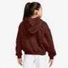 Mädchen in braunem Hoodie und weißen Shorts.