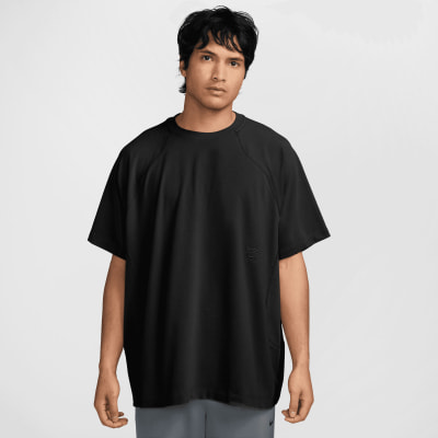 Ein Mann in einem schwarzen kurzärmeligen T-Shirt und grauen Shorts. Ein Mann in einem schwarzen kurzärmeligen T-Shirt und grauen Shorts.