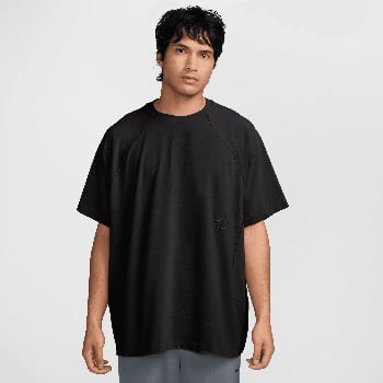 Ein Mann in einem schwarzen kurzärmeligen T-Shirt und grauen Shorts.