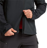Ein Mann öffnet eine schwarze Jacke und enthüllt ein rotes Hemd darunter.