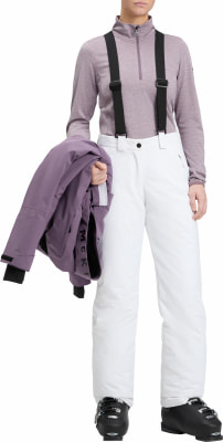 Frau in weißen Skihose, lila Jacke und Skischuhen. Frau in weißen Skihose, lila Jacke und Skischuhen.