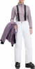 Frau in weißen Skihose, lila Jacke und Skischuhen.