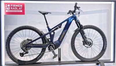 Ein blaues Trek E-Bike mit Federung auf einem Ständer im Geschäft.