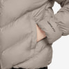 Detail einer Daunenjacke mit Therma-Fit-Logo am Ärmel und einer versteckten Tasche.
