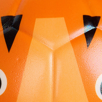 Detail eines orangefarbenen Kürbisses mit Wassertropfen und schwarzen Dreiecken. Detail eines orangefarbenen Kürbisses mit Wassertropfen und schwarzen Dreiecken.