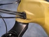 Gelber Fahrradrahmen mit schwarzer Kabeldurchführung.