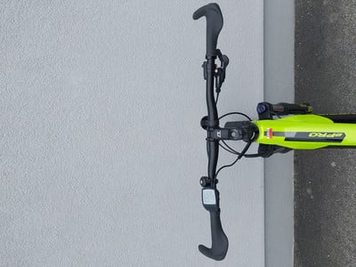 Grünes Fahrrad mit schwarzem Lenker und Fahrradcomputer auf grauem Untergrund. Grünes Fahrrad mit schwarzem Lenker und Fahrradcomputer auf grauem Untergrund.