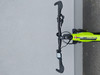 Grünes Fahrrad mit schwarzem Lenker und Fahrradcomputer auf grauem Untergrund.