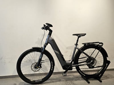 Graues E-Mountainbike mit Schutzblechen und Gepäckträger auf Ständer. Graues E-Mountainbike mit Schutzblechen und Gepäckträger auf Ständer.