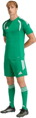 Ein Mann in einem grünen Fußballtrikot und Shorts mit weißen Streifen. Ein Mann in einem grünen Fußballtrikot und Shorts mit weißen Streifen.