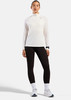 Frau in langärmeligem weißem Oberteil und schwarzer Leggings, Laufschuhe.