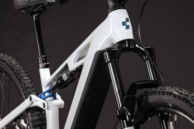 Detail eines weißen E-Bikes mit schwarzer Gabel und RockShox-Dämpfer.