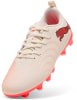 Beige Fußballschuhe von Puma mit rosa Logo und Sohle.