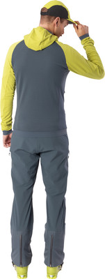 Ein Mann in Skibekleidung mit gelber Kapuze und grauer Hose. Ein Mann in Skibekleidung mit gelber Kapuze und grauer Hose.