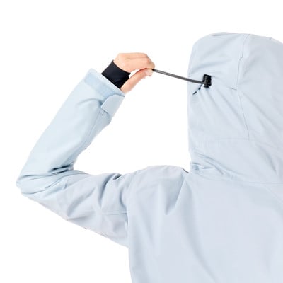 Eine Frau zieht die Kapuze einer Jacke auf weißem Hintergrund fest. Eine Frau zieht die Kapuze einer Jacke auf weißem Hintergrund fest.