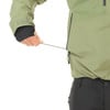 Detail einer Jacke mit einer Hand, die eine Kordel am Reißverschluss hält.