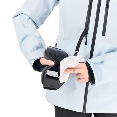 Eine Person reinigt eine Skibrille mit einem weißen Tuch. Eine Person reinigt eine Skibrille mit einem weißen Tuch.