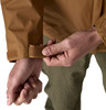 Ein Mann schließt den Klettverschluss am Ärmel einer Jacke am Handgelenk.