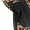 Detail einer schwarzen Jacke mit Leopardenmuster und Reißverschluss unter dem Arm.