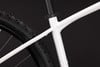 Detail eines weißen Mountainbike-Rahmens mit schwarzem Reifen.