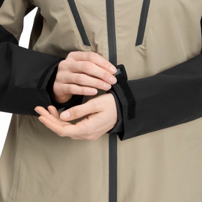Eine Frau schließt den Klettverschluss am Ärmel ihrer Jacke. Eine Frau schließt den Klettverschluss am Ärmel ihrer Jacke.
