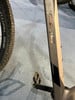 Detail eines Fahrradrahmens mit Logo und Pedal auf blauem Teppich.
