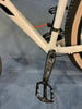 Nahaufnahme der Kurbel und Pedale eines weißen Mountainbikes.