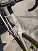 Detail eines weißen Rennrads mit blauem Logo und gelben Akzenten.