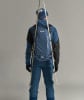 Ein Mann in Skibekleidung mit Rucksack und Skiern auf dem Rücken.