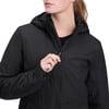 Eine Frau schließt eine schwarze Kapuzenjacke mit einem Reißverschluss.