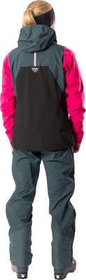 Rückansicht einer Skifahrerin in einem pink-grauen Anzug mit Stirnband.