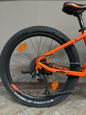 Hinterrad eines orangefarbenen Fahrrads mit Kette und Schaltwerk. Hinterrad eines orangefarbenen Fahrrads mit Kette und Schaltwerk.