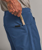Ein Mann steckt eine kleine Bürste in die Tasche einer blauen Hose.