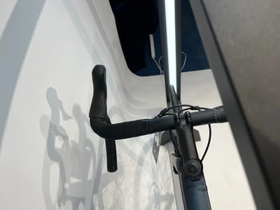 Nahaufnahme des Lenkers und Vorbaus eines Rennrads mit schwarzem Lenkerband. Nahaufnahme des Lenkers und Vorbaus eines Rennrads mit schwarzem Lenkerband.