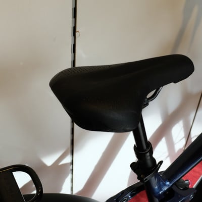 Eine schwarze Fahrradsattelstütze mit perforiertem Sattel und verstellbarem Mechanismus. Eine schwarze Fahrradsattelstütze mit perforiertem Sattel und verstellbarem Mechanismus.
