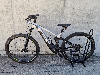 Silber-schwarzes E-Mountainbike mit Federung auf einem Ständer.