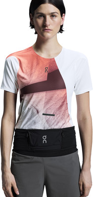 Frau in einem Laufshirt mit abstraktem Muster und schwarzem Hüftgurt. Frau in einem Laufshirt mit abstraktem Muster und schwarzem Hüftgurt.