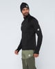 Ein Mann in einem schwarzen Oberteil und grüner Hose mit Mammut-Logo.