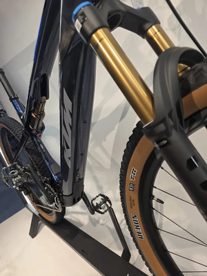 Detail eines Mountain-E-Bikes mit Federung und goldener Gabel. Detail eines Mountain-E-Bikes mit Federung und goldener Gabel.