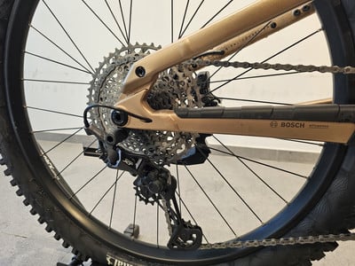 Goldener E-Bike-Rahmen mit Schaltwerk und Bosch-Kassette. Goldener E-Bike-Rahmen mit Schaltwerk und Bosch-Kassette.