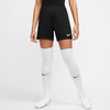 Schwarze Fußballshorts für Damen mit weißen Socken und Schuhen.