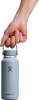 Eine Hand hält eine hellblaue Hydro Flask Flasche mit Griff.