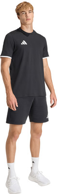 Ein Mann in einem schwarzen T-Shirt und Shorts mit weißen Streifen und Turnschuhen. Ein Mann in einem schwarzen T-Shirt und Shorts mit weißen Streifen und Turnschuhen.