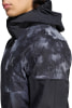 Detail einer Kapuzenjacke mit Wassertropfen und einem schwarz-grauen Druckmuster.
