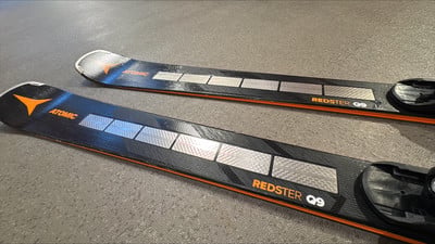 Zwei Atomic Redster Q9 Ski mit orange-silbernen Details auf schwarzem Grund.