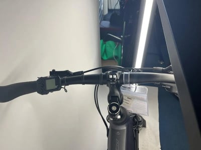 Detail des E-Bike-Lenkers mit Display und Shimano Deore Bremshebel.