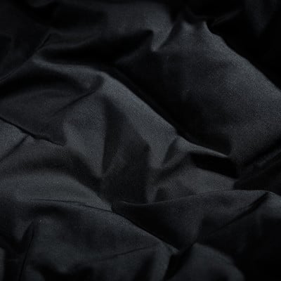 Schwarzer, gesteppter Stoff mit mattem Glanz und deutlicher Textur.