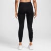 Schwarze Damenleggings mit seitlichem Logo und weißen Turnschuhen.