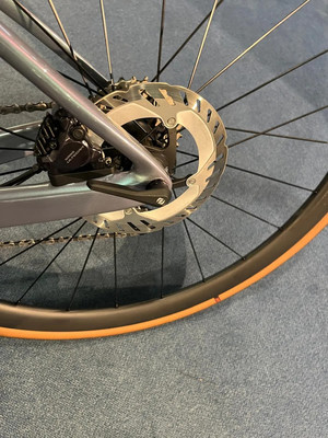 Hinterrad eines Fahrrads mit Scheibenbremse und orangefarbenem Reifen. Hinterrad eines Fahrrads mit Scheibenbremse und orangefarbenem Reifen.